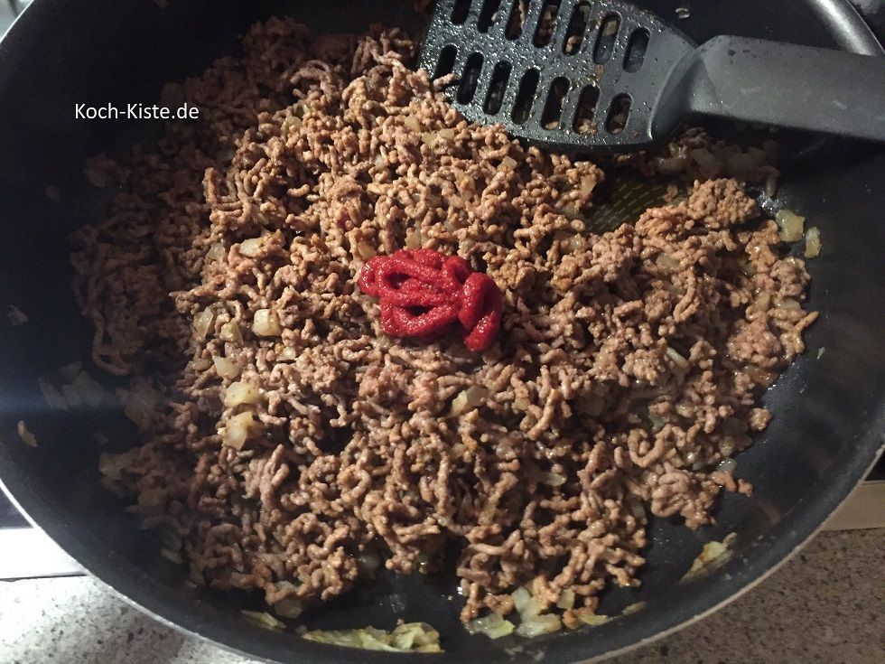 gebe das Tomatenmark hinzu und rühre es mit dem Pfannenwender gleichmäßig unter.