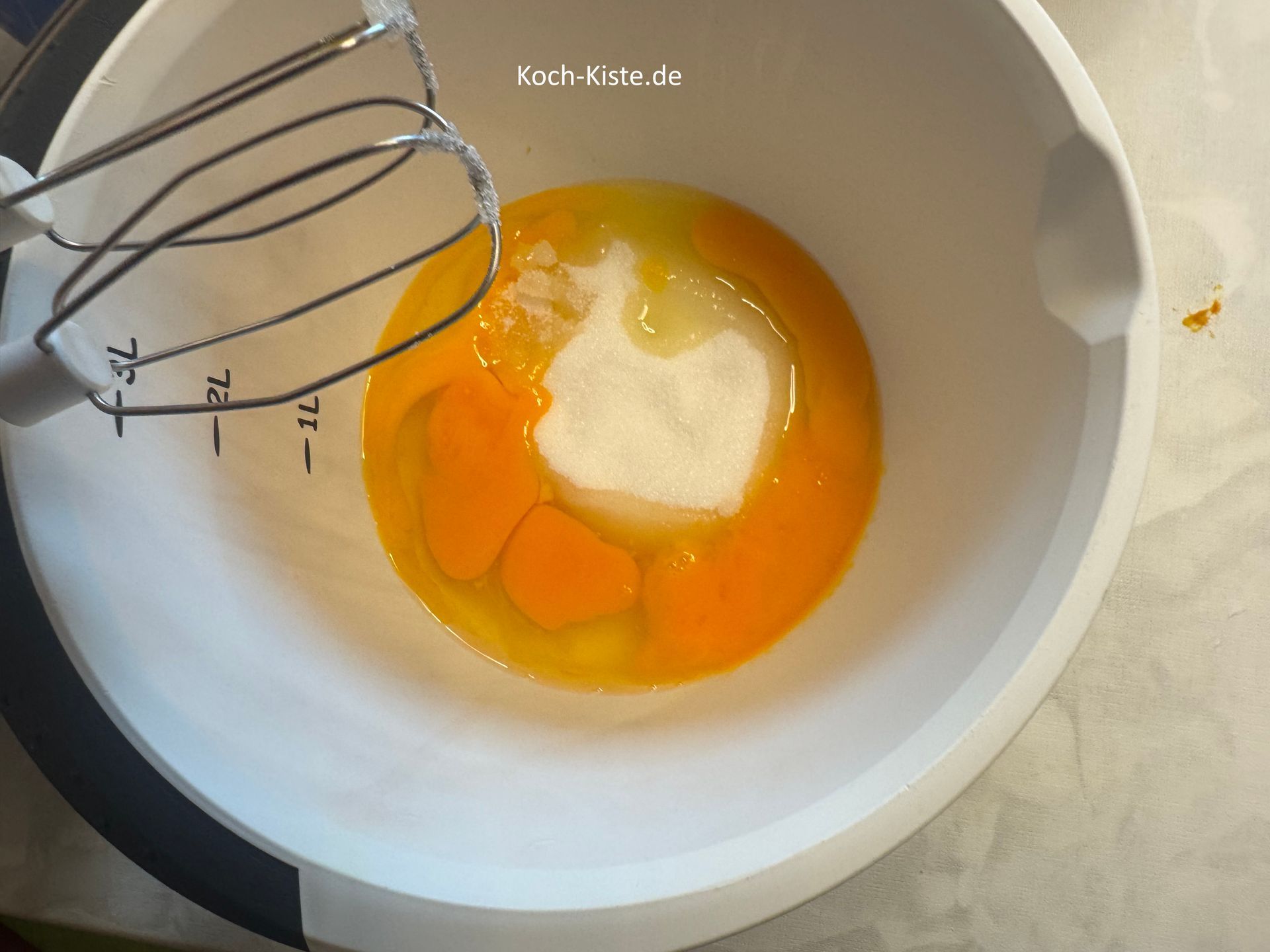 stelle die Rührschüssel mit den Eiern auf die Küchenwaage auf 0 und wiege 250g Zucker ab