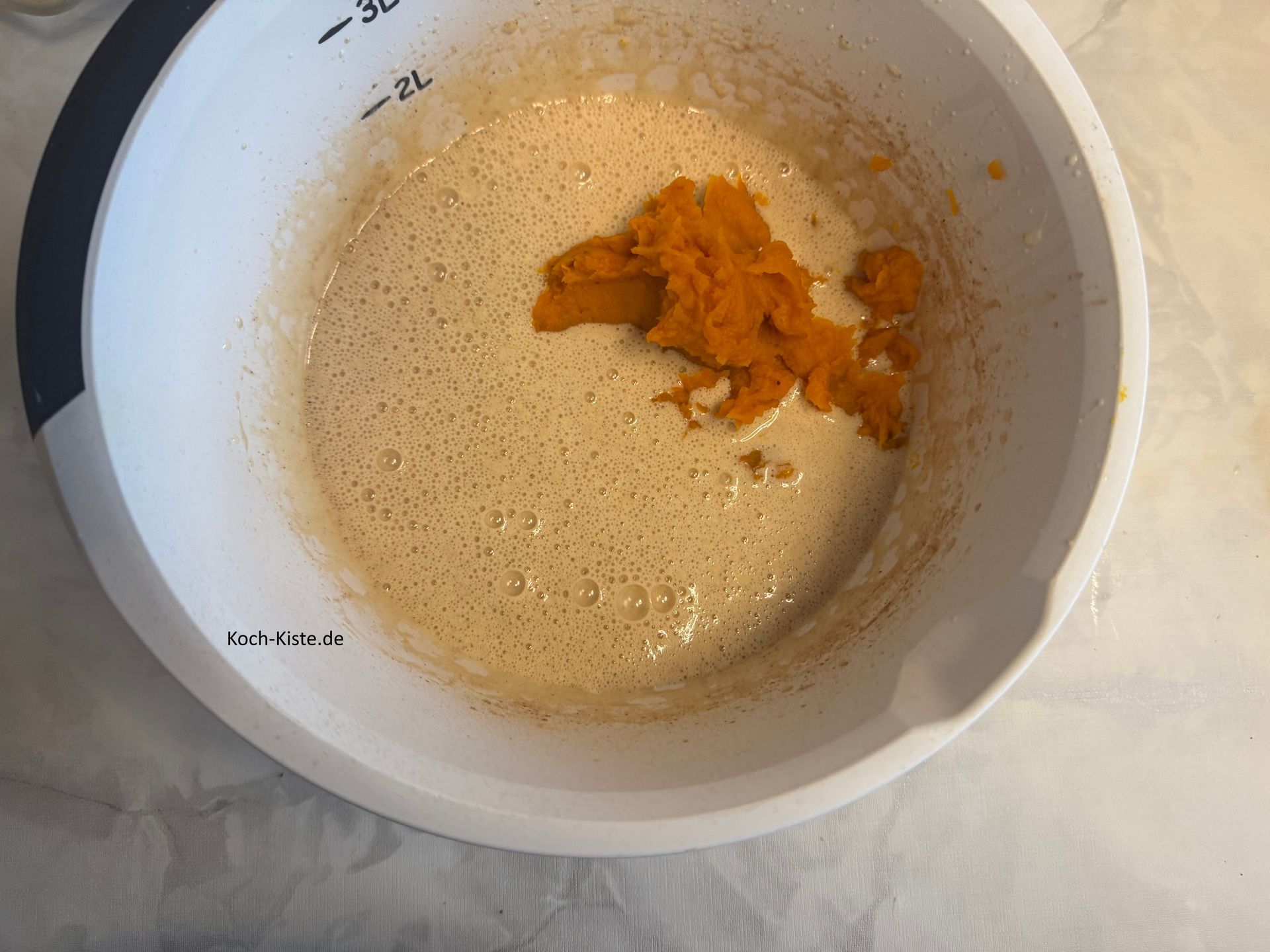 danach gebe mit Hilfe eines Teiglöffels den Kürbismus mit in die Rührschüssel