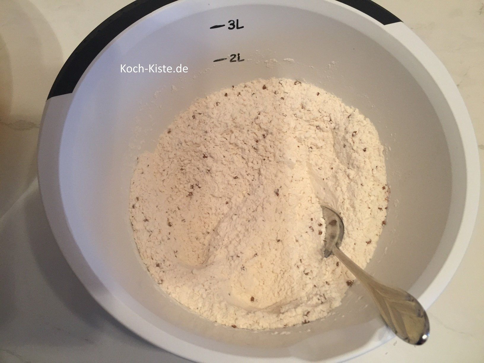 gebe in eine extra Schüssel Mehl, Instant-Kaffeepulver, Kokosraspel und Backpulver. Verrühre die Zutaten mit einem Löffel.