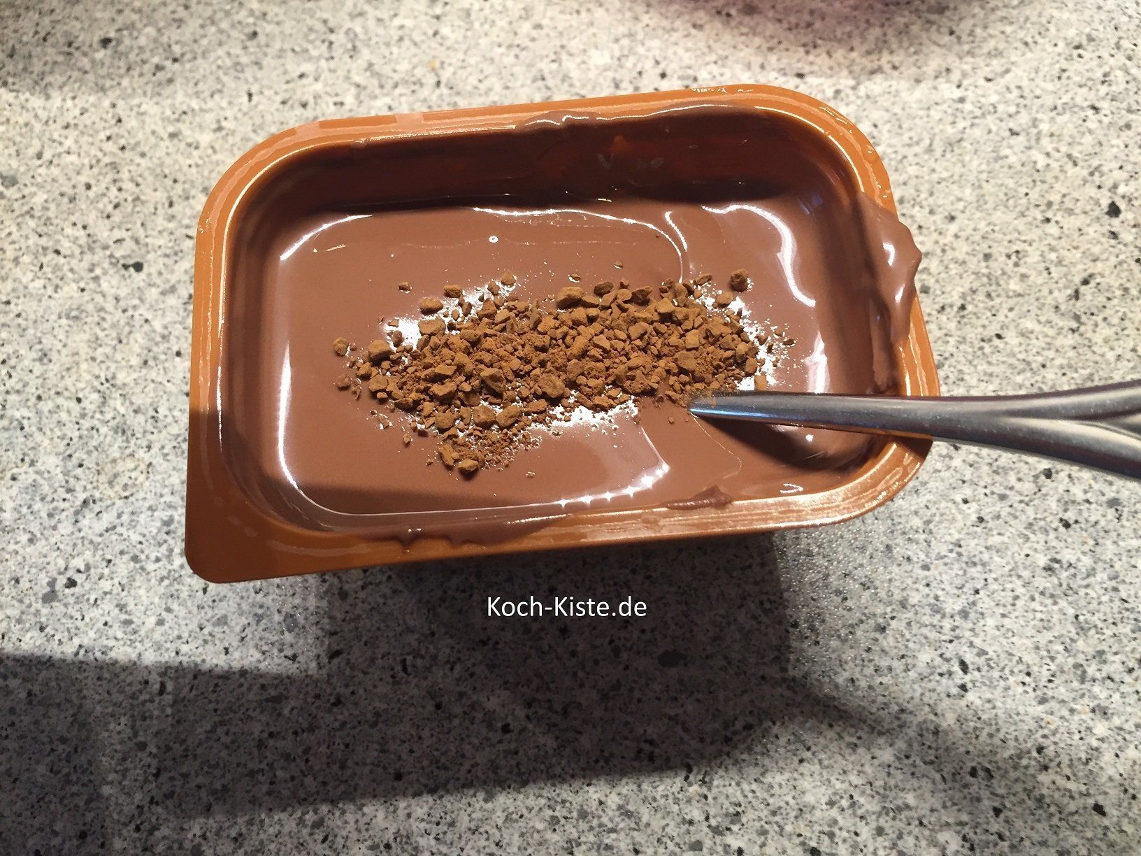 schmelze im heißen Wasserbad die Schokoladenglasur und rühre Instant-Kaffeepulver unter.