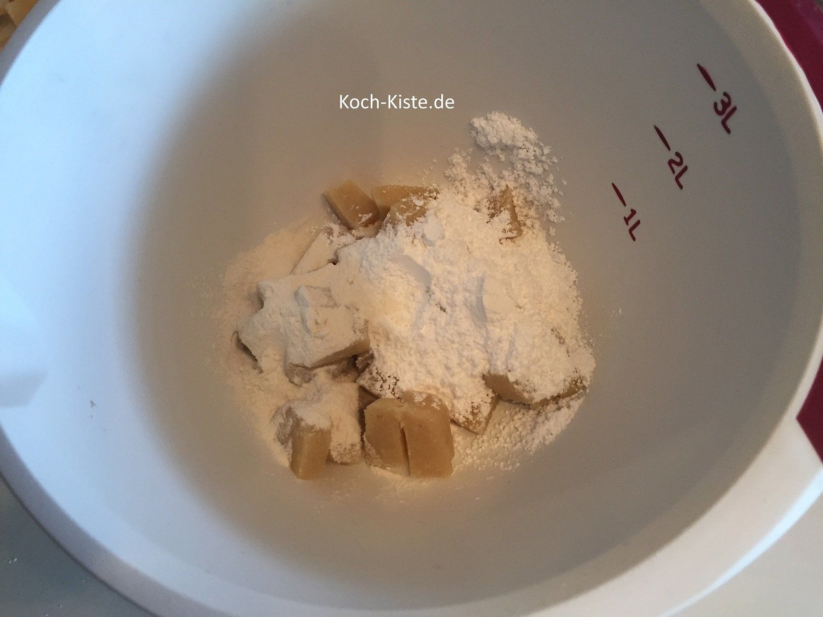Marzipanstücke, Puderzucker, Mehl in die Rührschüssel