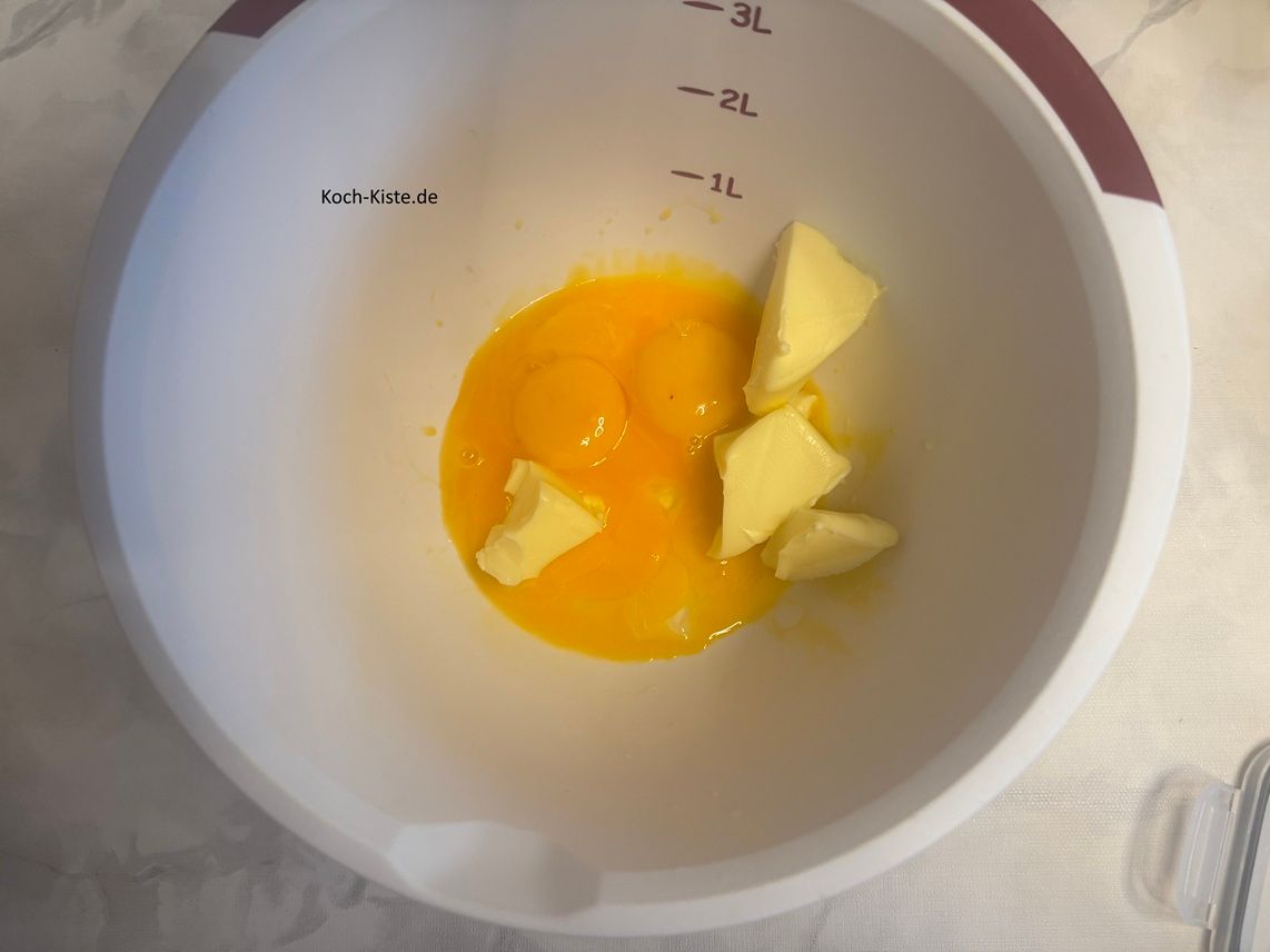stelle die Rührschüssel mit den Eigelben auf eine Küchenwaage auf 0 und schubse mit einem Schmiermesser 100g (200g) Butter hinein