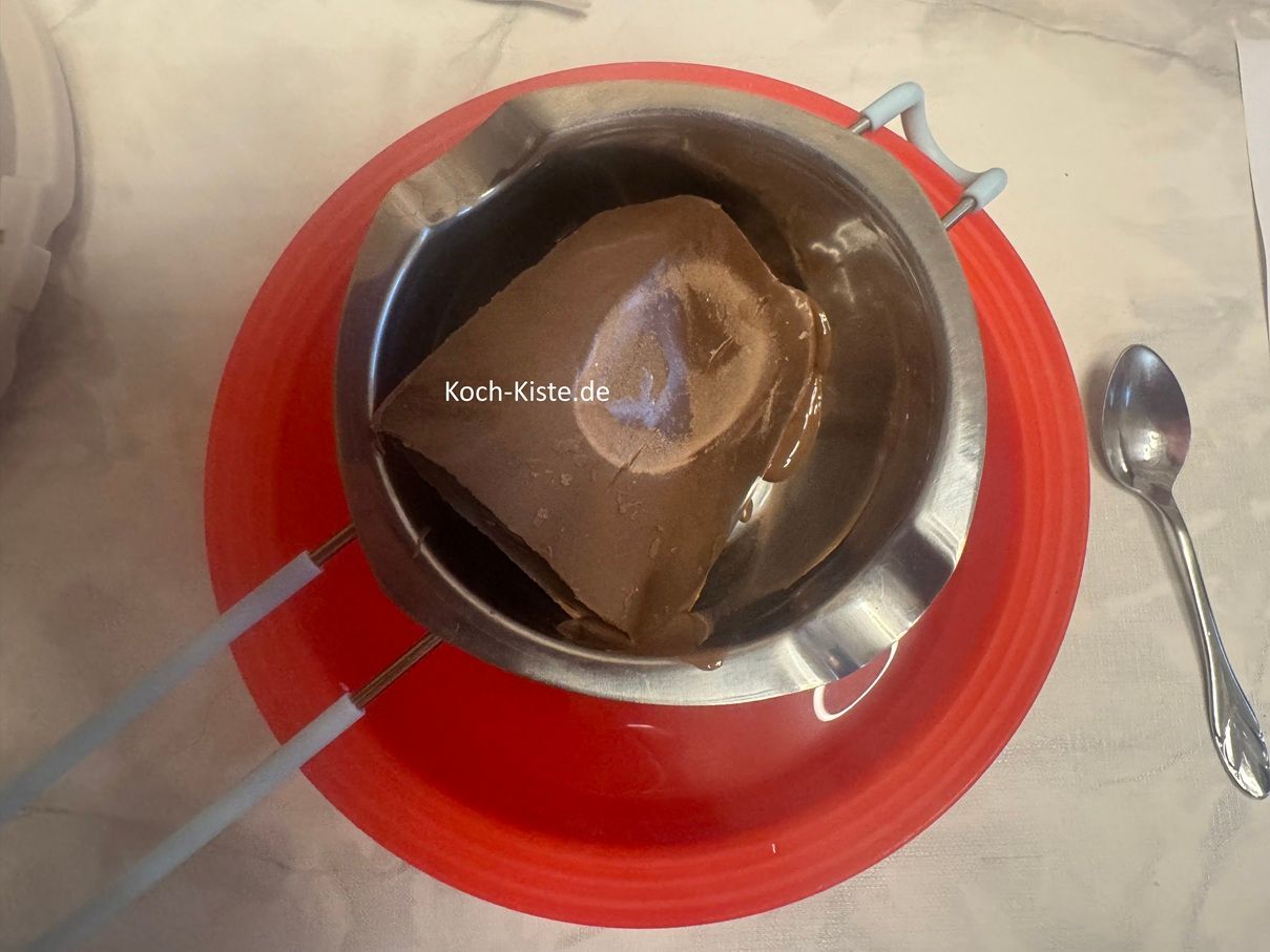 in der Zwischenzeit lege eine Schmelzschale auf eine Schüssel und gebe Kuvertüre / Schokoladenglasur in die Schmelzschale .