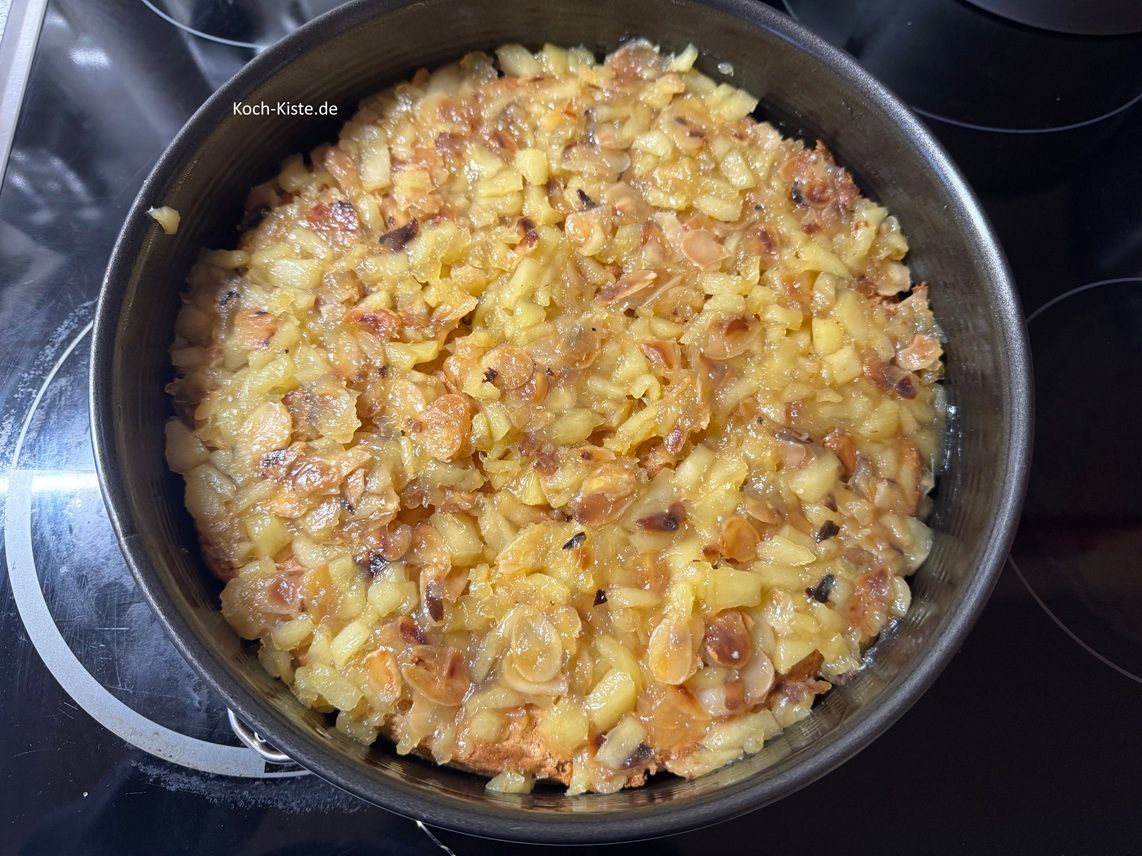 nun gebe die Apfel-Mandel Mischung auf den Bisquittboden. Dafür verteile die Mischung in vielen kleinen Portionen auf dem Bisquitteig - Du kannst die Apfel-Mandel Mischung nicht weitflächig verstreichen - dann bricht der Bisquittboden kaputt.