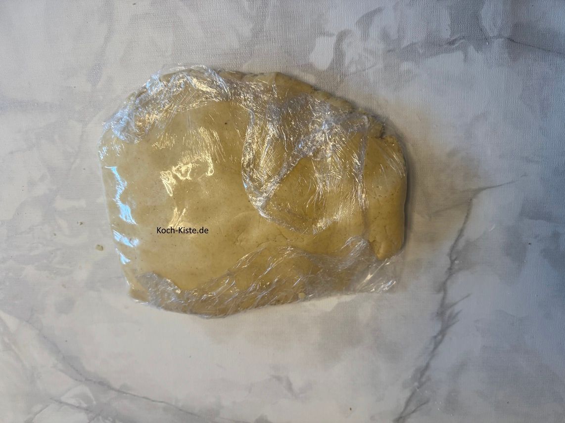 gebe den Teig auf die Frischhaltefolie und wickel den Teig ein. Dann lege den Teig für 1 Stunde in den Kühlschrank.