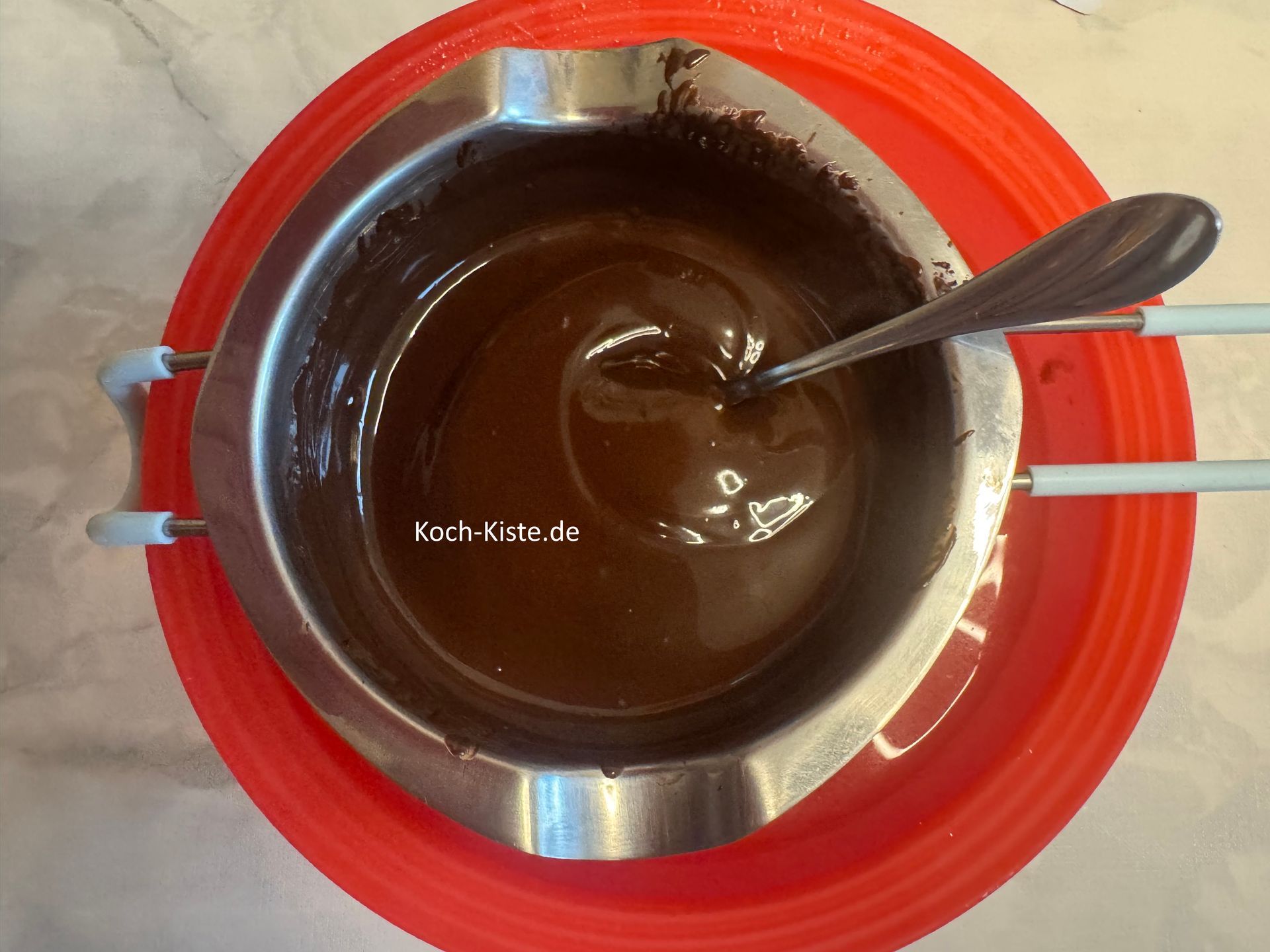 verrühre die Kuvertüre mit dem Teelöffel bis sie geschmolzen ist