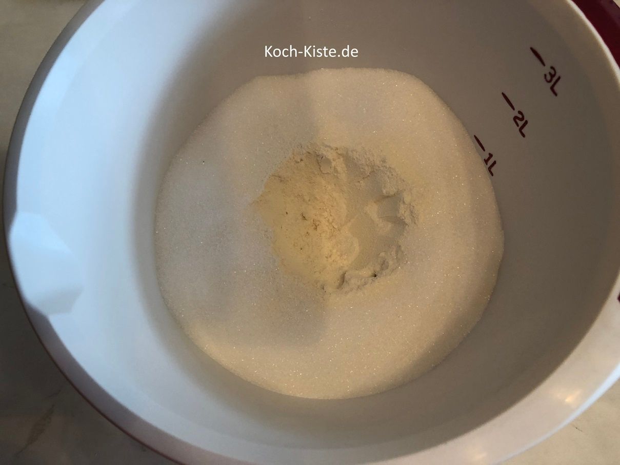 als nächstes stelle die Rührschüssel wieder auf die Küchenwaage auf 0 und gebe 125 g Zucker auf den Mehlrand .