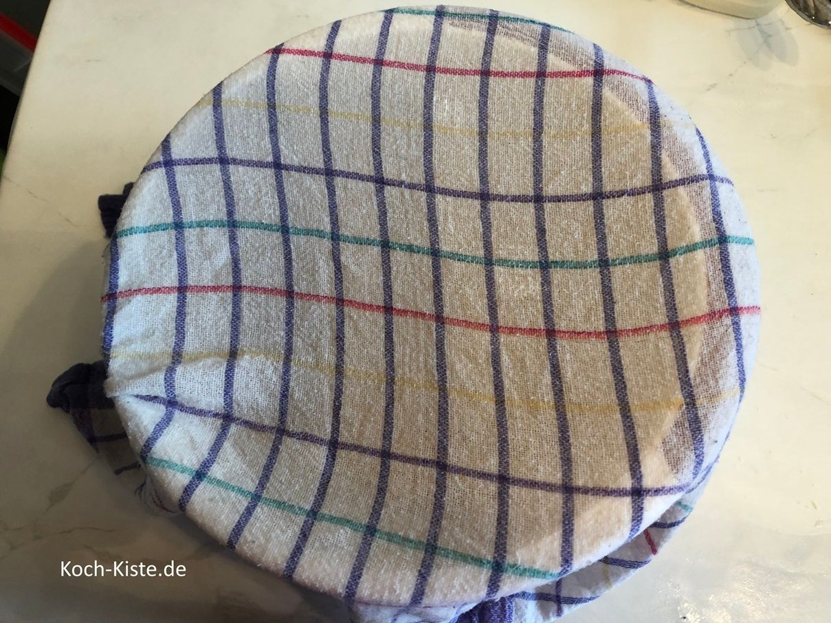 nimm das frische Geschirrhandtuch und halte es unter fast heißes, fließendes Wasser, wringe es nur so weit aus, dass es nicht tropft und lege es über die Rühhrschüssel