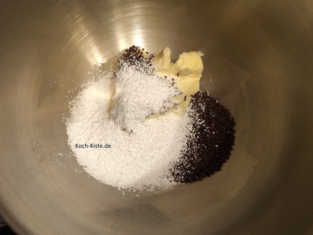 gebe Butter, Schokostreusel und gesiebten Puderzucker in eine Rührschüssel