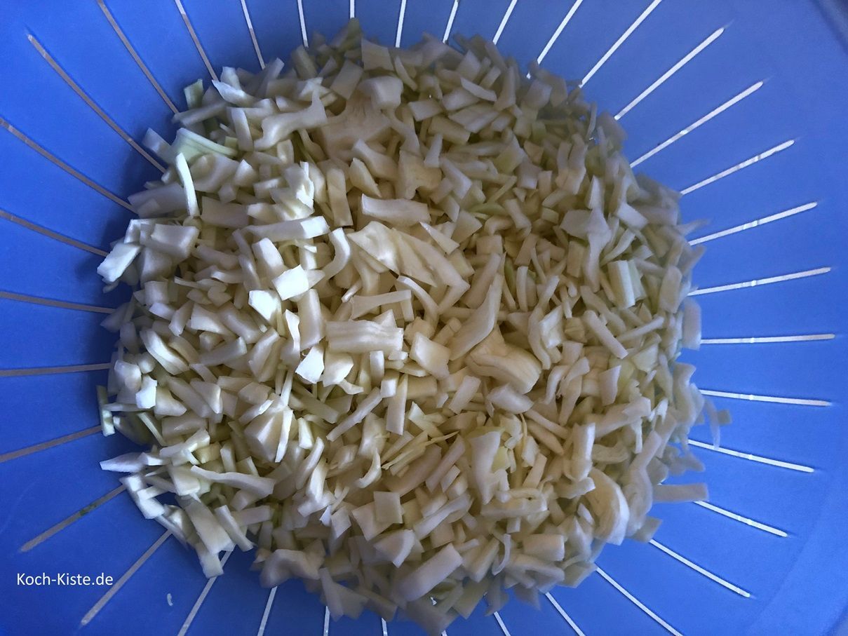 gebe die Weißkohlstücke in ein Küchensieb und spüle sie unter kaltem, fließendem Wasser ab.