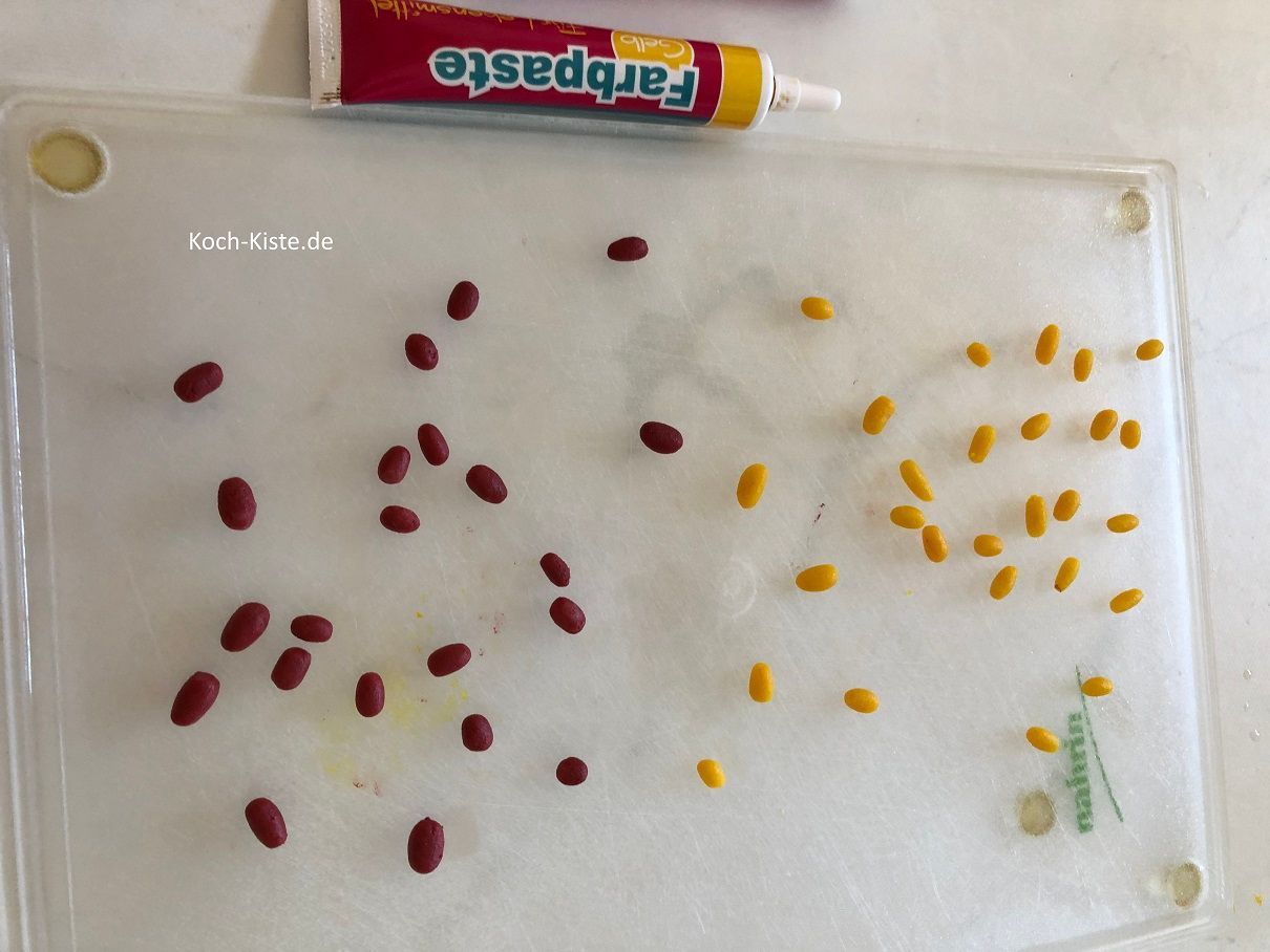 teile die Marzipanmenge und färbe eine Hälfte rot und die andere Hälfte gelb ein , dann forme kleine Ostereier