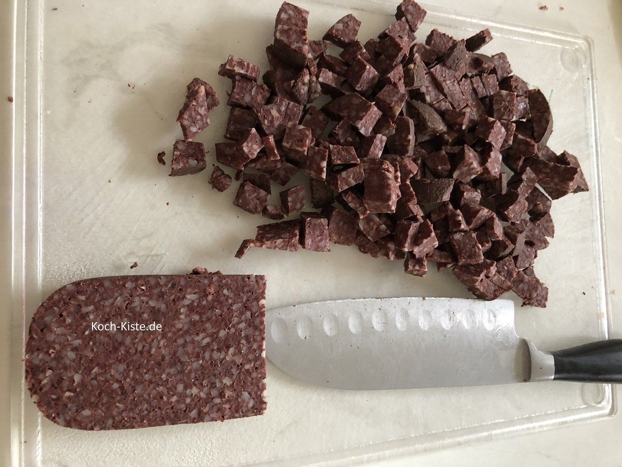 schneide die Grützwurst erst in Scheiben und dann  in kleine Stücke