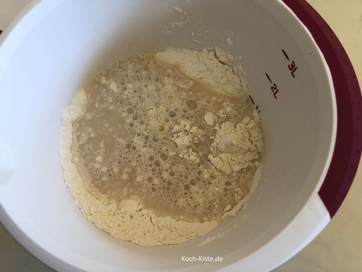 Ziehe Dir Vinyl-Einmalhandschuhe an , gieße das Hefewasser mit in die Rührschüssel und verknete alles mit den Händen