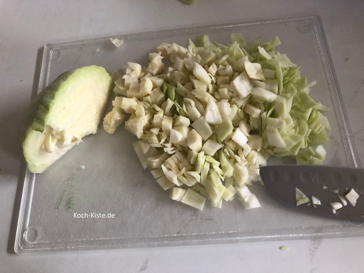 dann schneide den Weißkohl in Scheiben, danach in Streifen und zum Schluss in kleine Stücke
