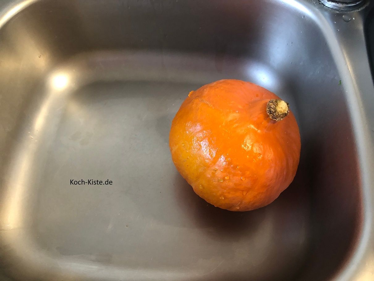 kippe den Hokkaido Kürbis in die Küchenspüle und spüle ihn mit kaltem, fließendem Wasser ab