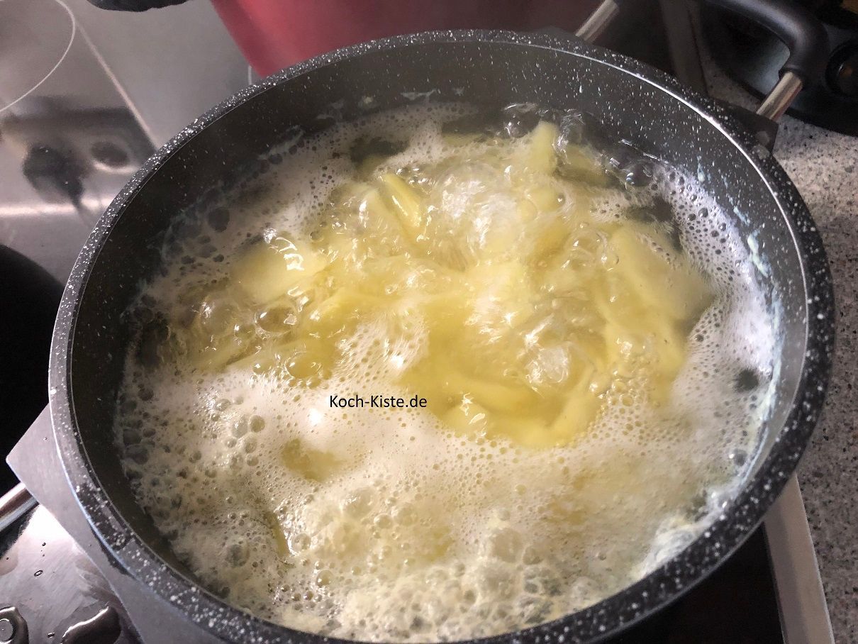 Die Kartoffeln sollten nun gar sein. Stelle dir das Küchensieb in die Spüle und gieße die Kartoffelscheiben hinein. Lasse die Kartoffelscheiben abtropfen .