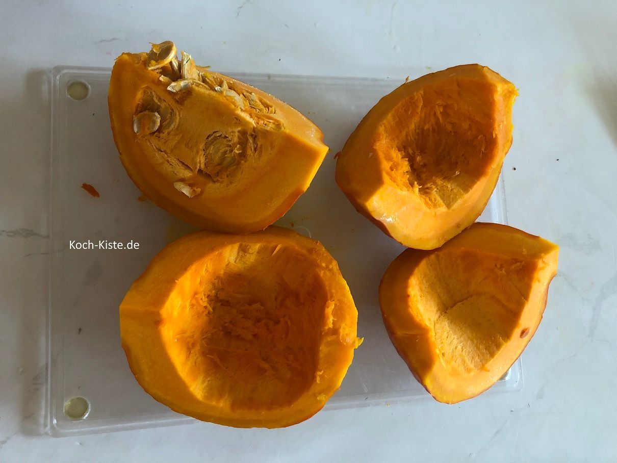 lege den Hokkaido Kürbis auf das Schneidebrett und halbiere ihn. Dann viertel ihn und entferne die Kerne