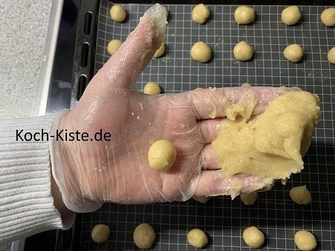 ein Teil auf die Fingerspitzen legen , ein Stück Teig abnehmen und in der Handfläche zur Kugel formen