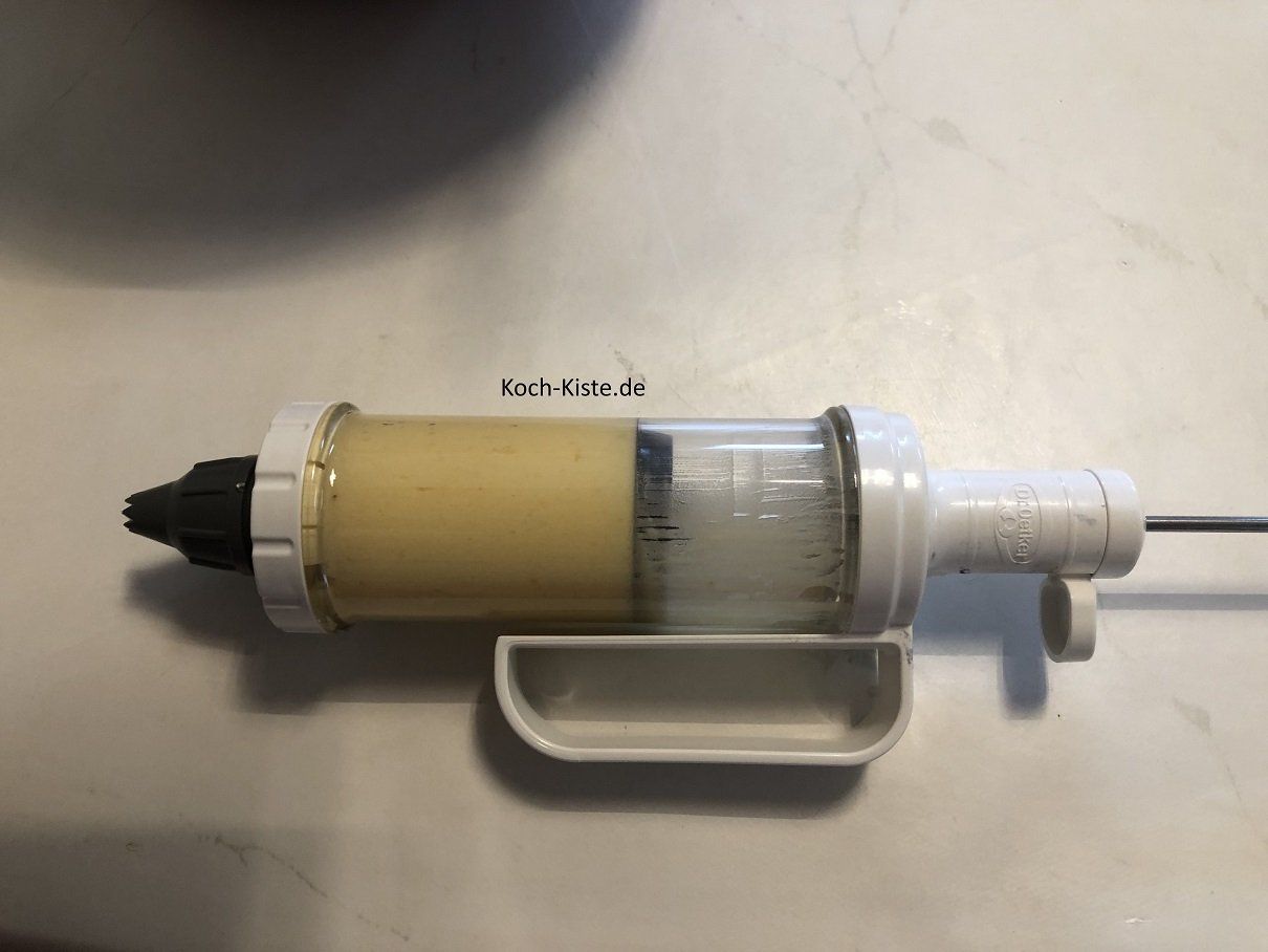 Teig mit Hilfe des Teiglöffels in die Gebäckpresse füllen