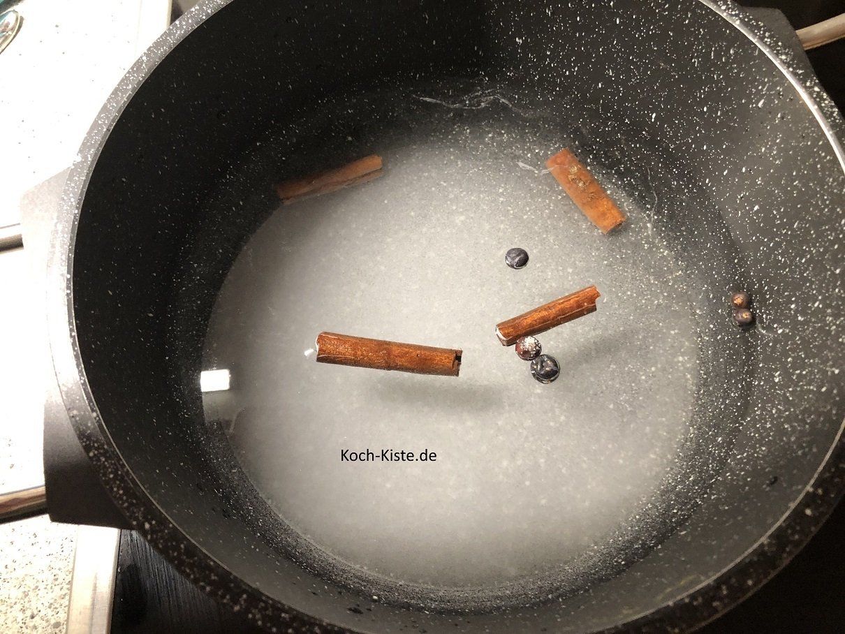Wasser, Zimtstangen, Nelkenkörner und Zucker in einen Topf geben