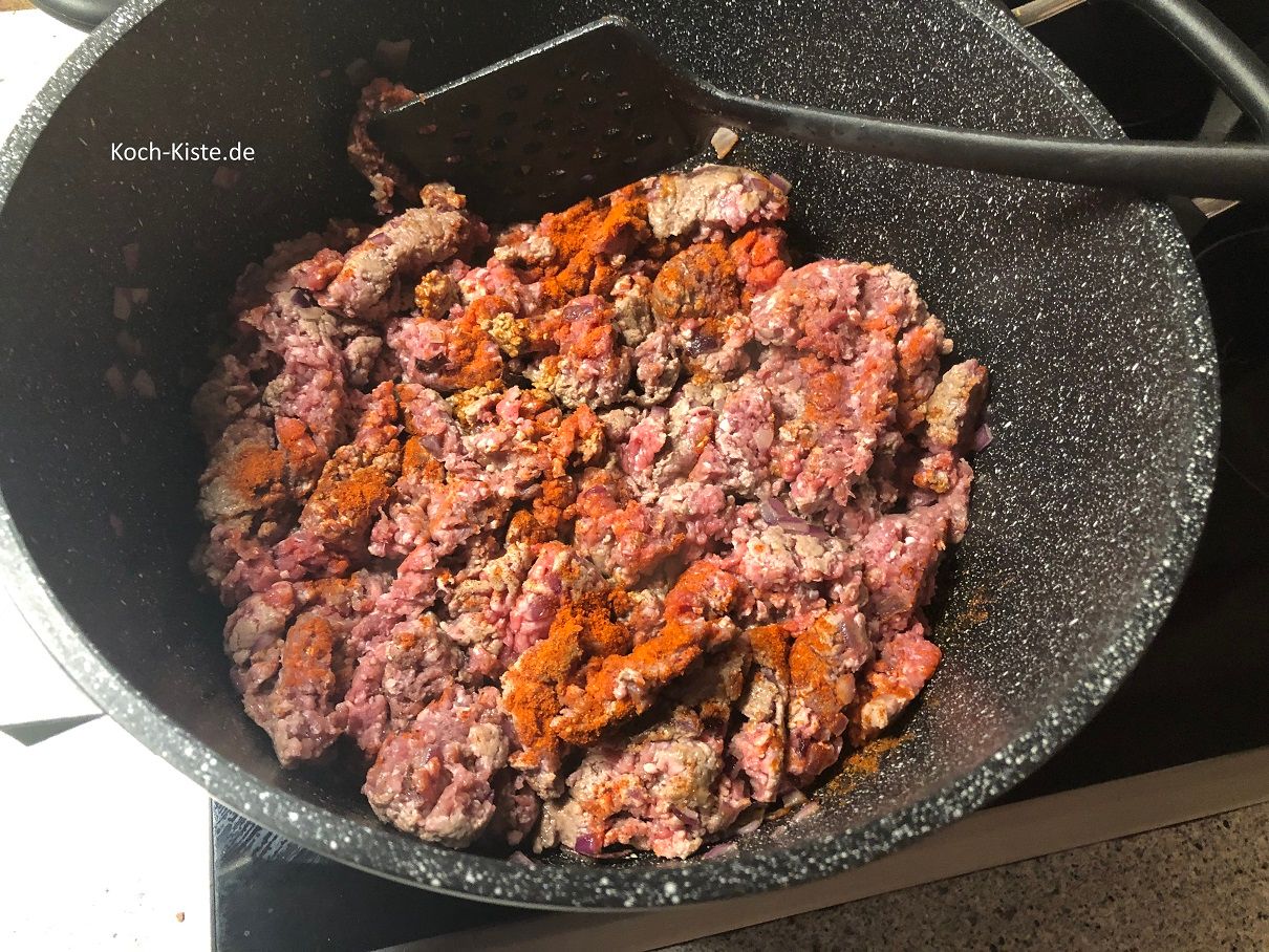 Hackfleisch und Gewürze mit in den Topf geben