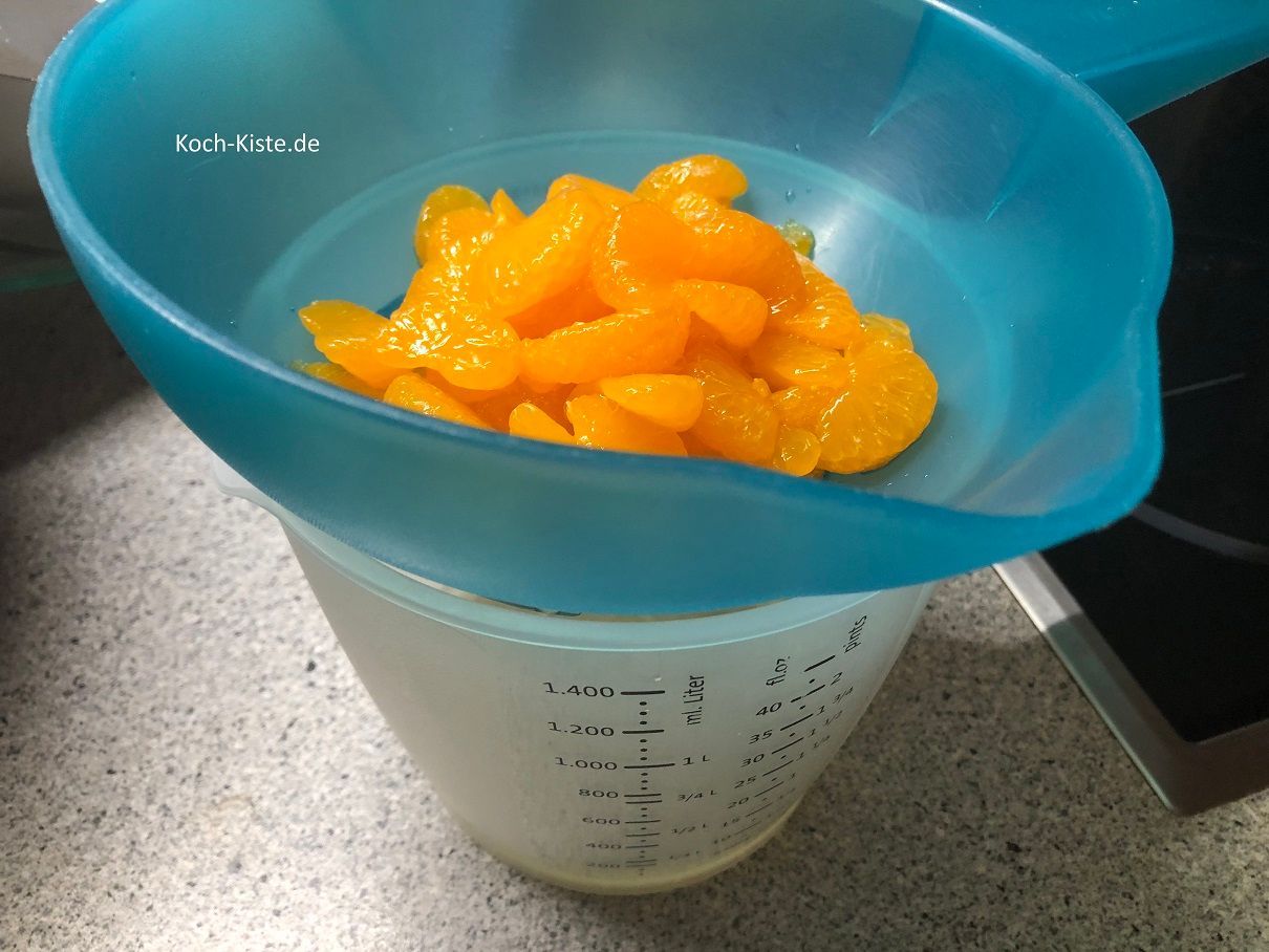 Mandarinen über ein Küchensieb abkippen und dabei den Saft auffangen