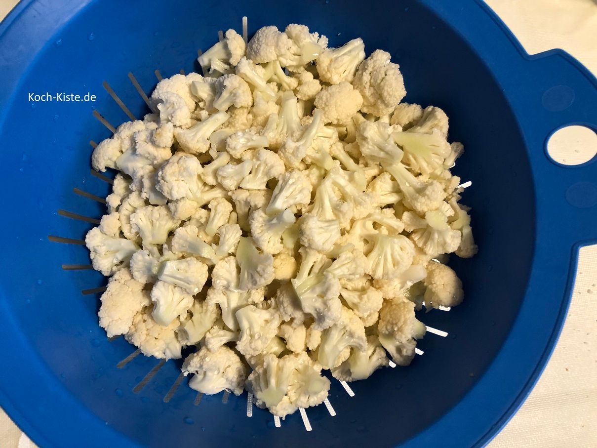 gebe die Blumenkohlröschen in das Küchensieb und spüle sie unter kaltem, fließendem Wasser ab.