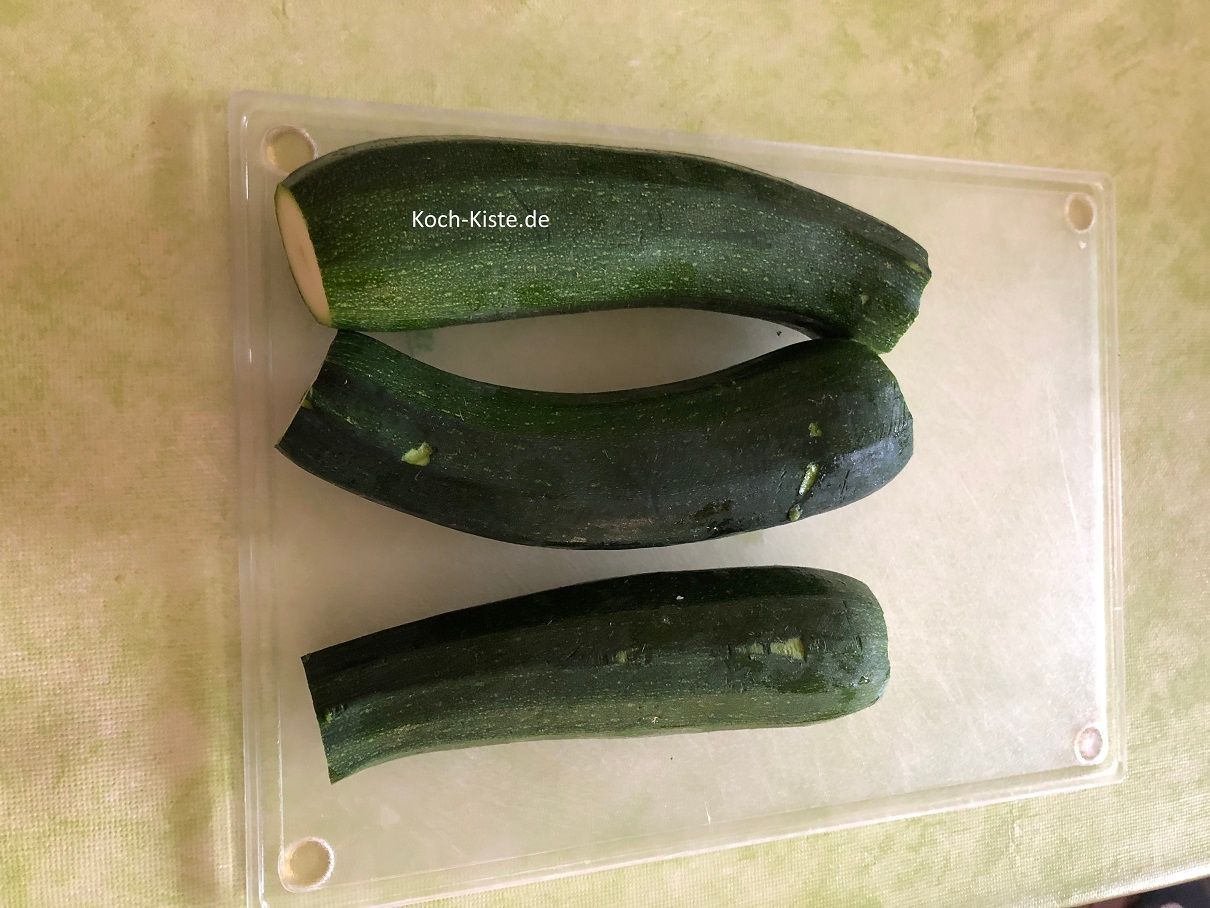 spüle die Zucchinis unter kaltem, fließendem Wasser ab und entferne dann von jedem Ende ein kleines Stück