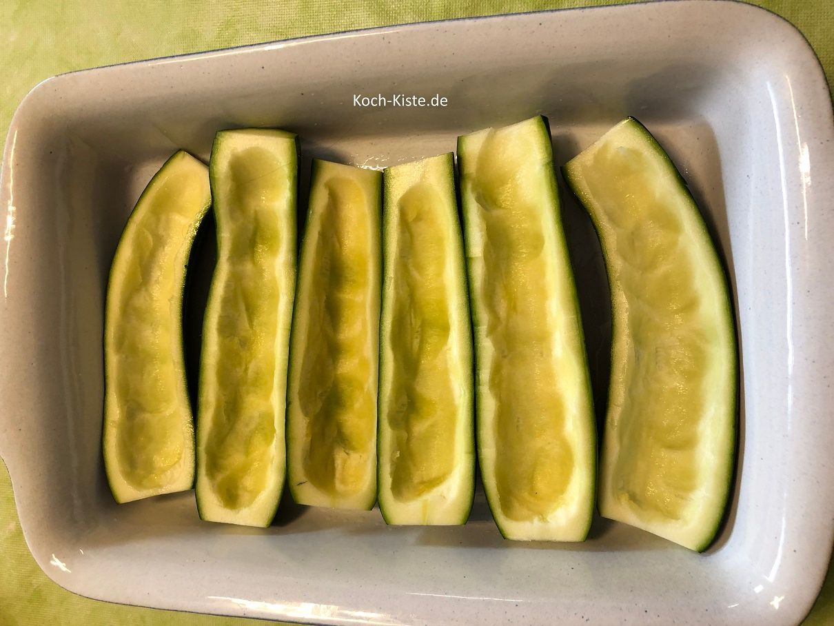 die ausgehölten Zucchini werden in eine gefettete Auflaufform gelegt