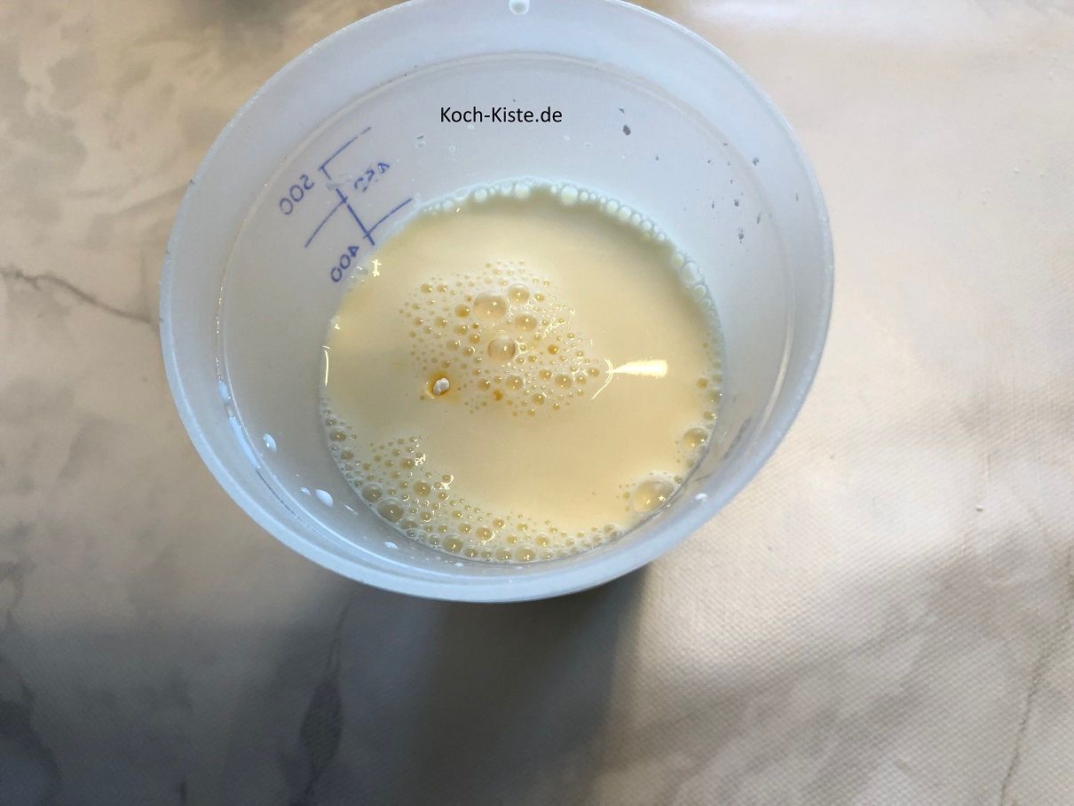 Gebe in einen Messbecher Öl, Milch und das Puddingpulver und verrühre alles miteinander, dann gieße die Flüssigkeit mit zur Quark-Masser