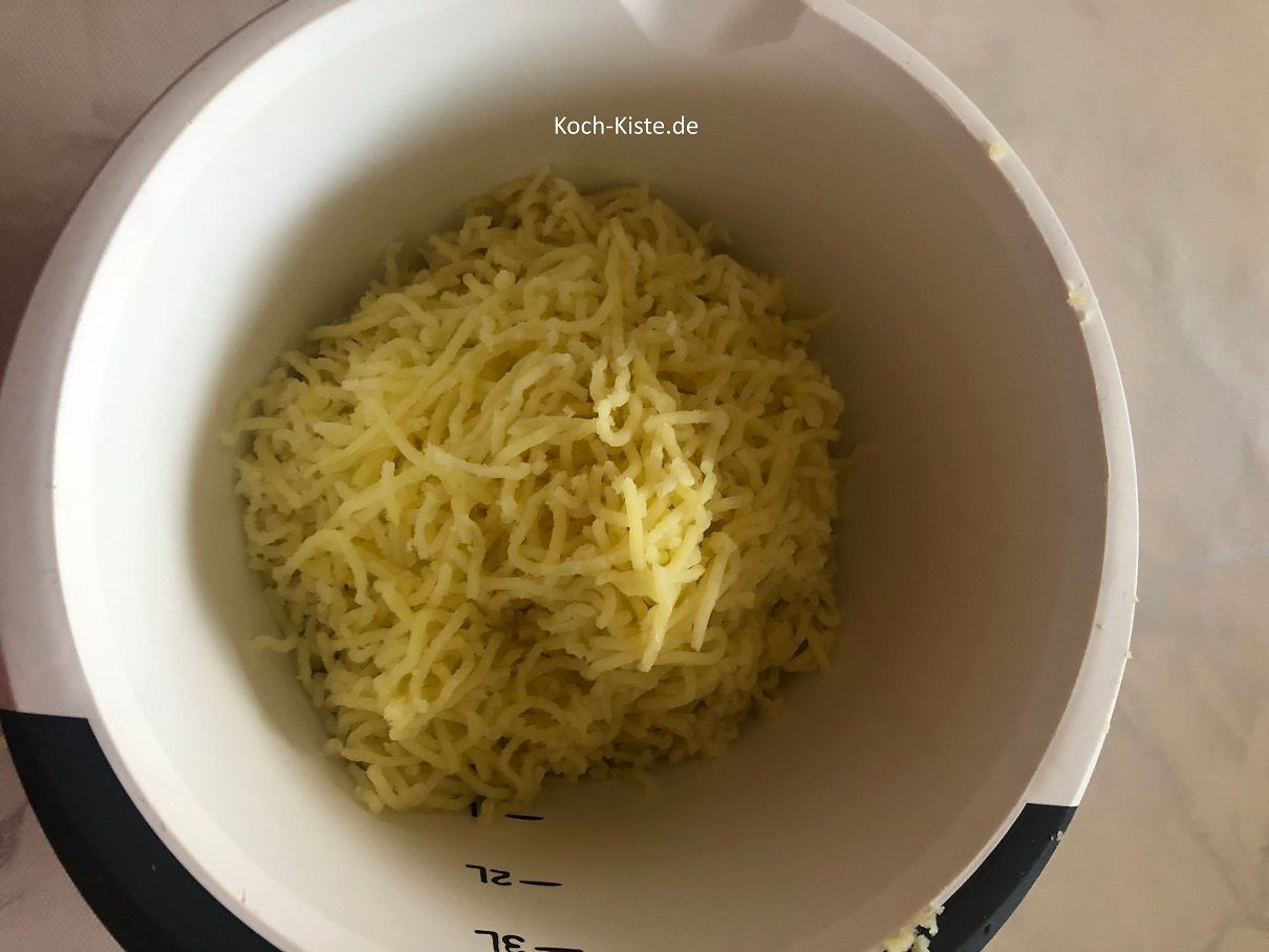 presse die Kartoffeln durch die Kartoffelpresse in die Rührschüssel oder zerstampfe sie mit dem Kartoffelstampfer