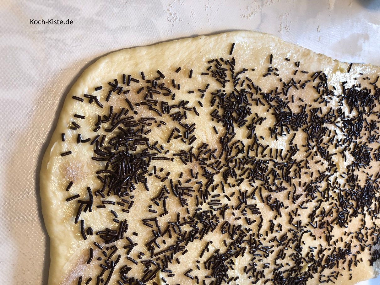 verteile 70 Gramm Schokostreusel gleichmäßig auf den Teig
