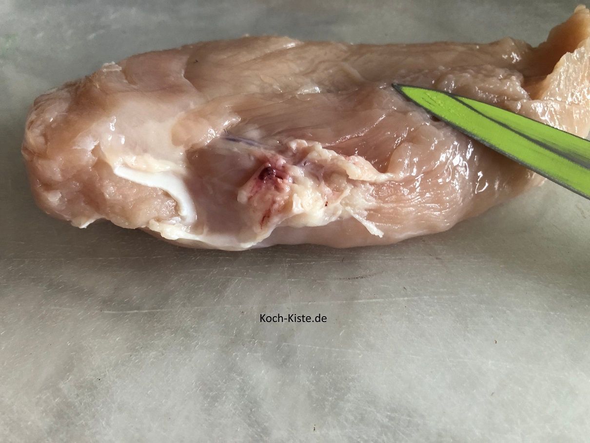 Hähnchenbrustfilet aufs Schneidebrett legen, mit Küchenpapier trocken tupfen