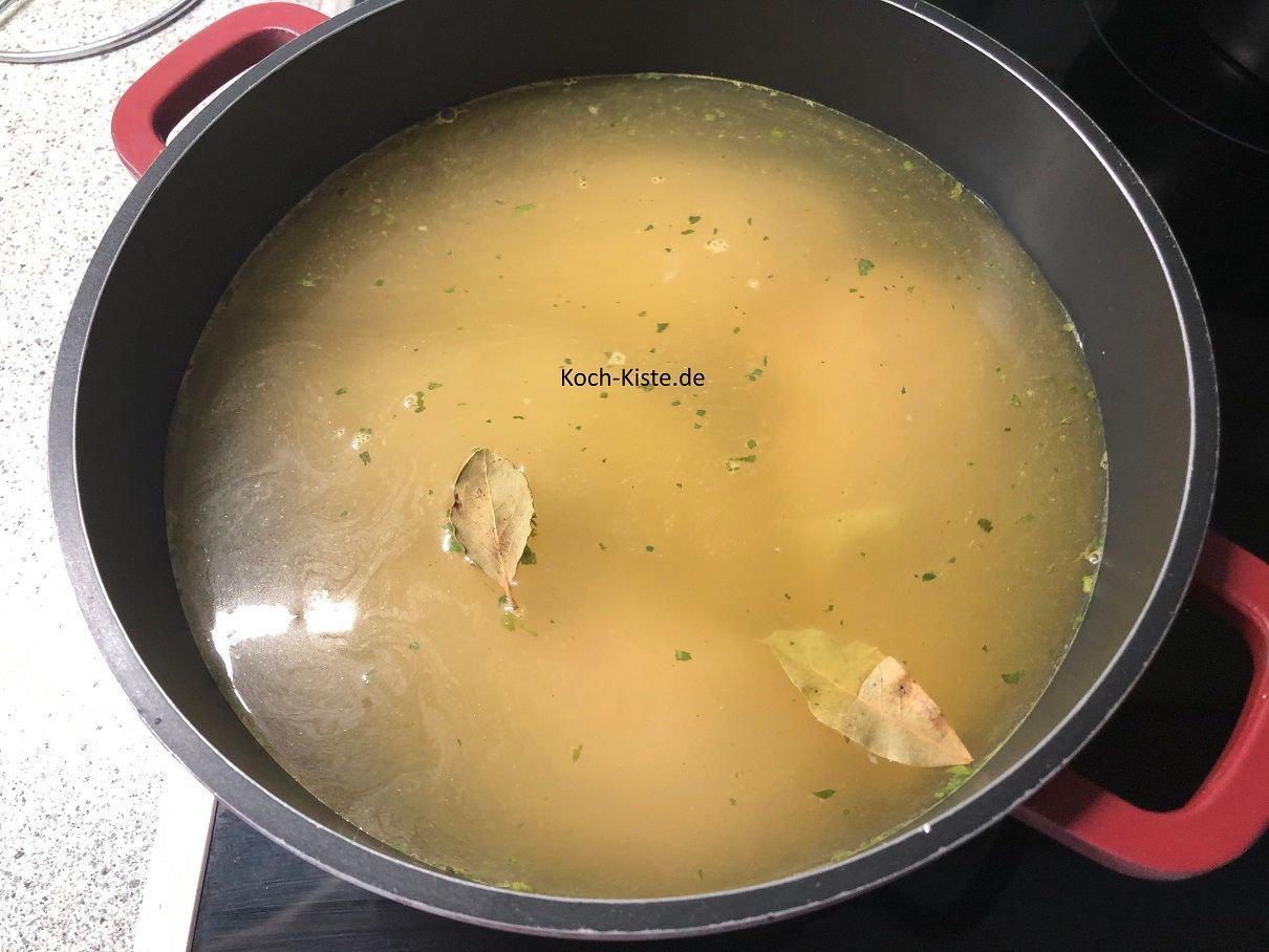 Hühnerbrühe in den Topf gießen und Lorbeerblätter oben auf legen