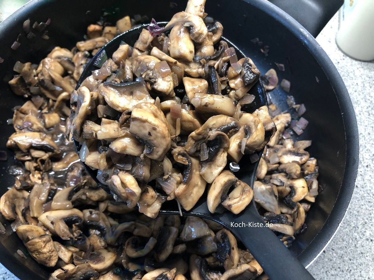 Nehme die Champignons mit einer Schaumkelle aus der Pfanne und lasse die Flüssigkeit abropfen