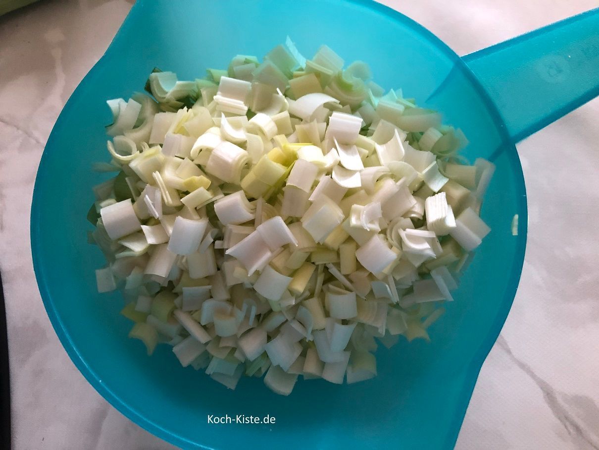 klein geschnittenen Porree in ein Küchensieb geben und unter kaltem, fließendem Wasser abspülen