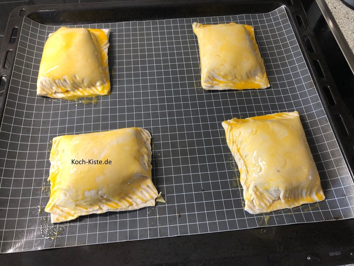 lege die Blätterteigplatten auf ein Backblech und bestreiche sie mit Eigelb