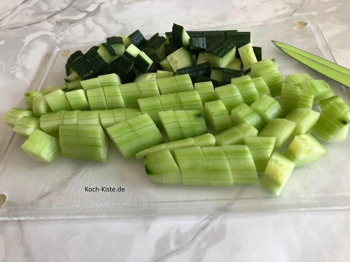 dann schäle 1 Gurke und schneide die geschälte und die übrige 1/2 Gurke mit Schale in kleine Stücke