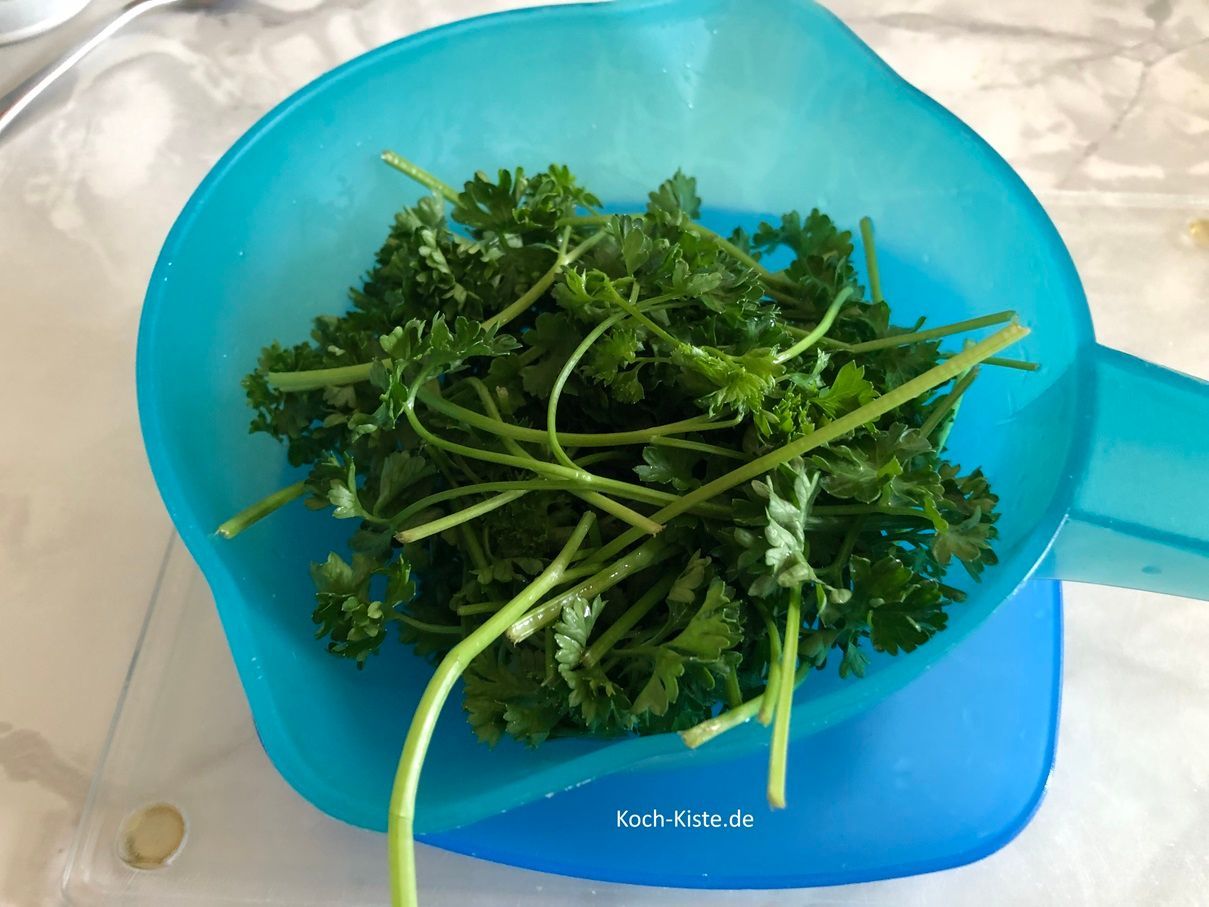 gebe die Petersilienstiele in das Küchensieb und spüle sie unter kaltem, fließendem Wasser ab