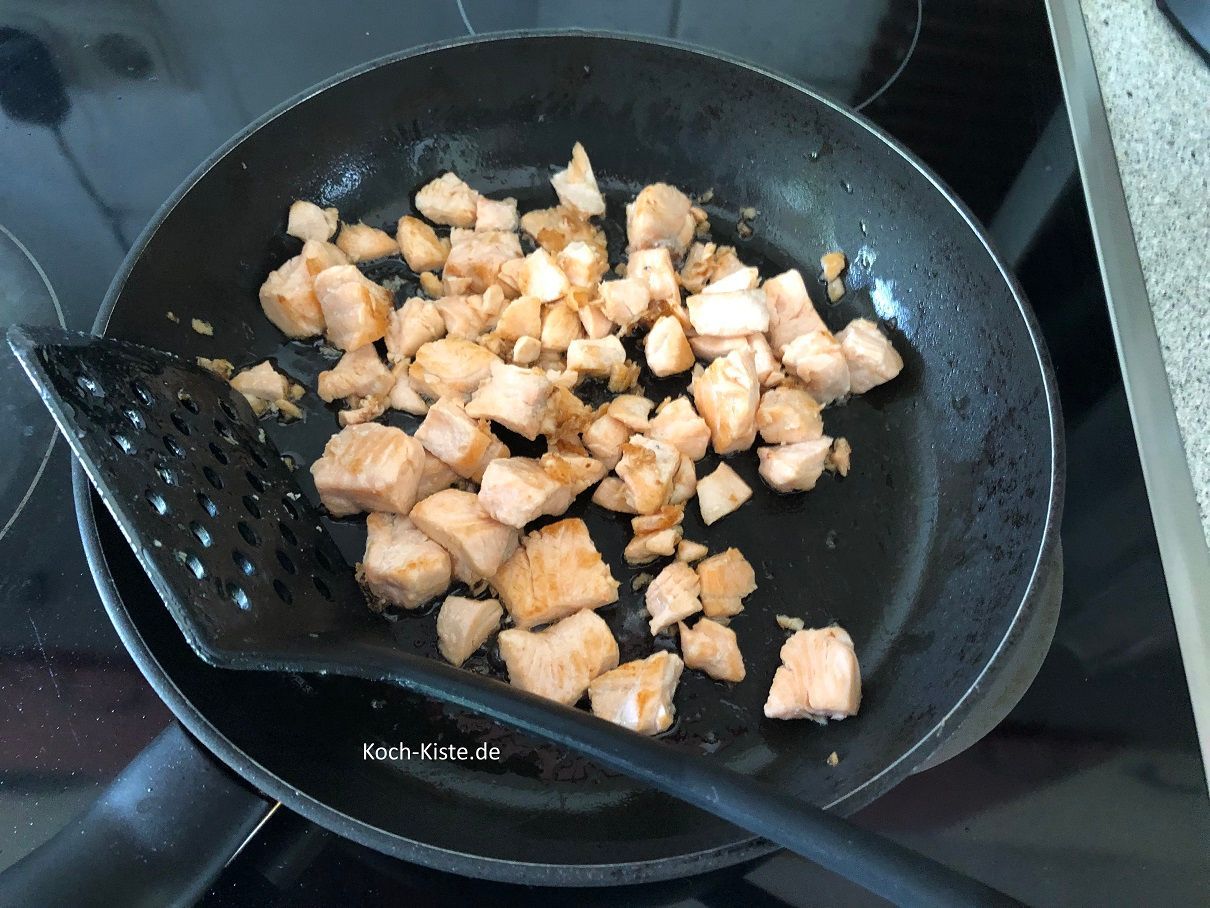 fertig gebratenes Lachsfilet wird in eine Schale gegeben