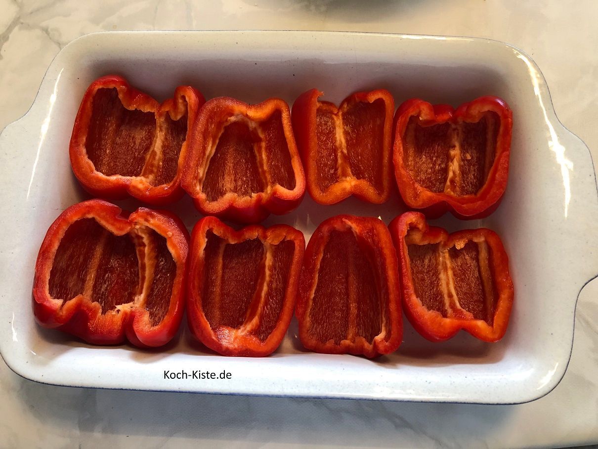 Nehme Dir eine Auflaufform und lege die Paprikahälften hinein