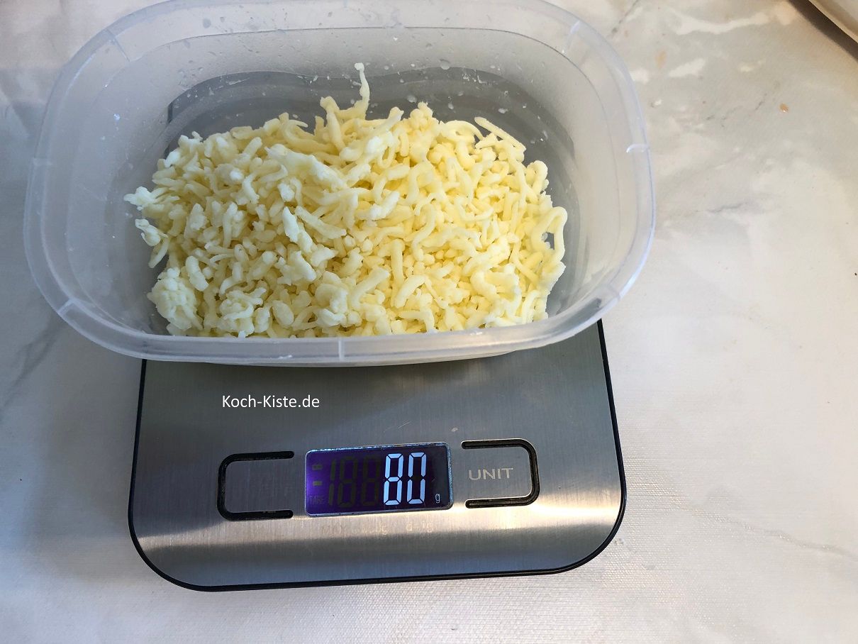 wiege in der Feta--Schüssel 80 Gramm geriebenen Käse ab
