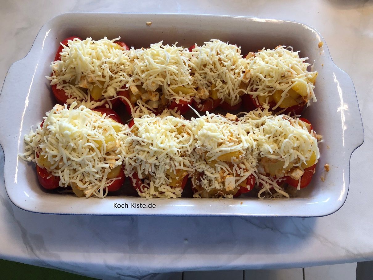 zum Schluss verteile 100 Gramm geriebenen Käse über die Paprikahälften