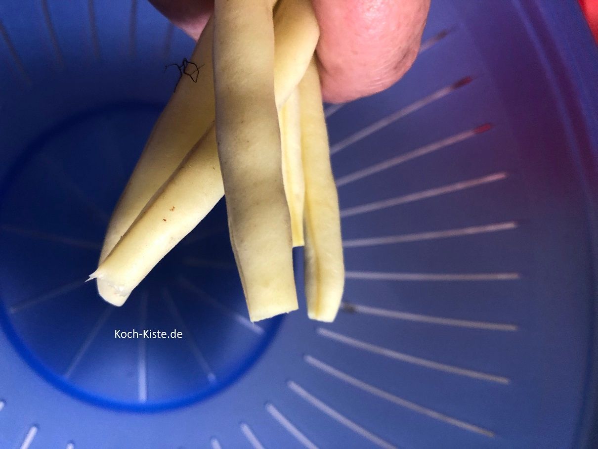 nun nehme Dir eine Wachsbohne und entferne oben und unten ein Stück. Behalte die Wachsbohne in der Hand und nehme die nächste , bis Du 4-5 Wachsbohnen in der Hand hast.