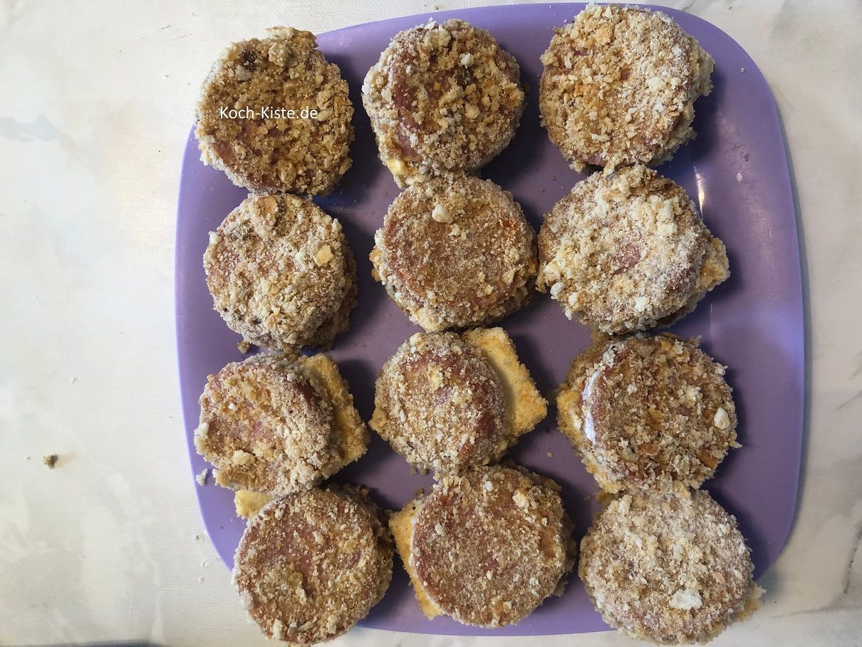 die fertig panierten Salamistücke kommen auf einen Teller