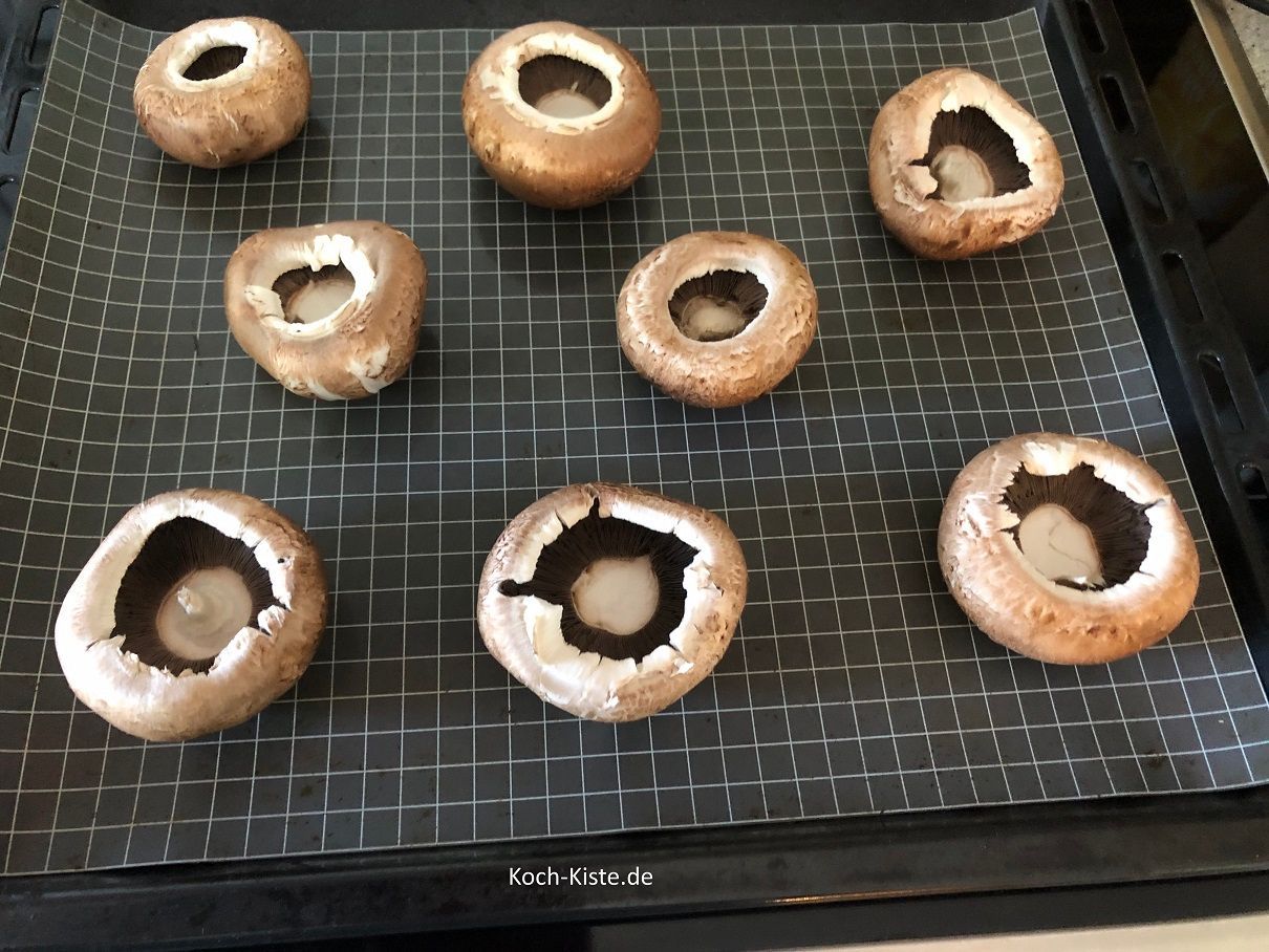 dann lege die Pilze mit der Kopfseite nach unten auf ein Backblech mit Backpapier oder Backmatte