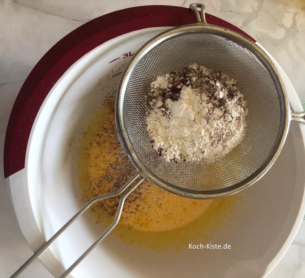 als nächstes lege ein Sieb über die Rührschüssel und siebe Dinkelmehl, Speisestärke und Kakaopulver