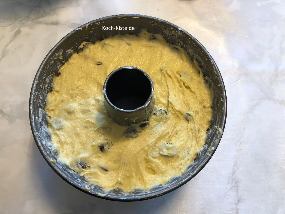 mit Hilfe eines Esslöffels fülle den Teig in die Kuchenform