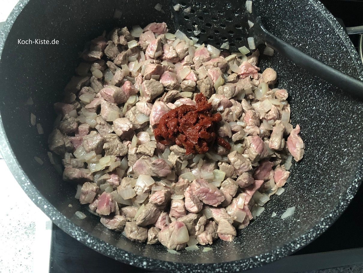 nun gebe das Tomatenmark mit in den Topf und rühre es mit dem Pfannenwender gleichmäßig unter